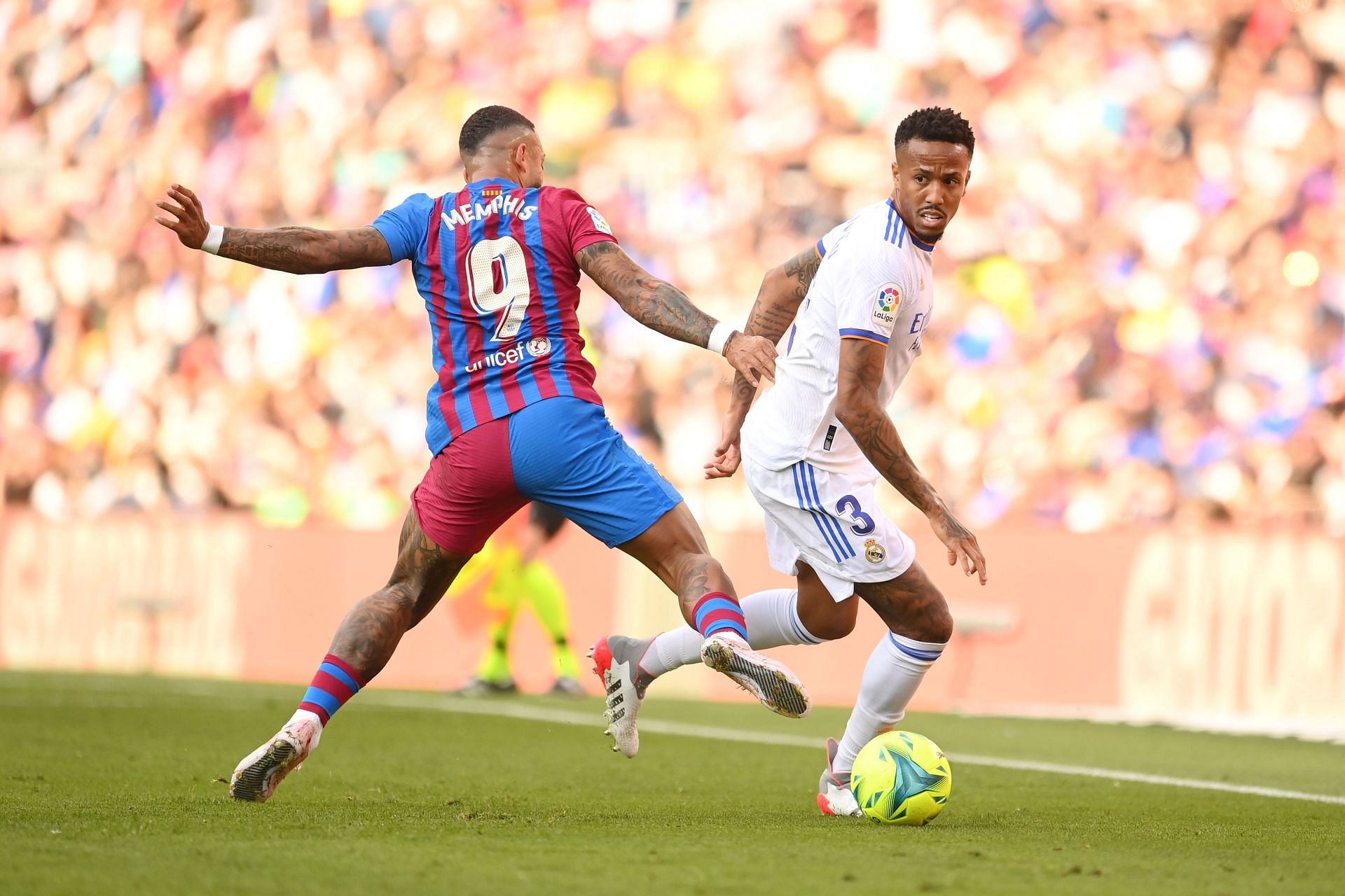 Real Madrid's Eder Militao (#3) gets past Memphis Depay (#9) of Barcelona